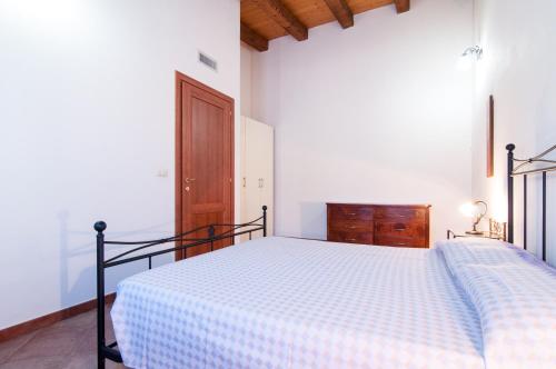a bedroom with a bed and a wooden door at Le Case Al Quadrato Residence in Siracusa