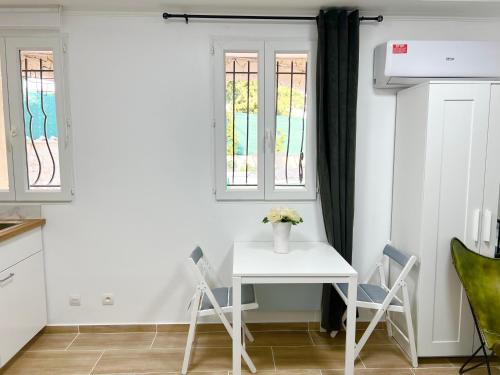 une petite table et des chaises blanches dans la cuisine dans l'établissement Villa Prestige Soleil & 2 plage, à Nice