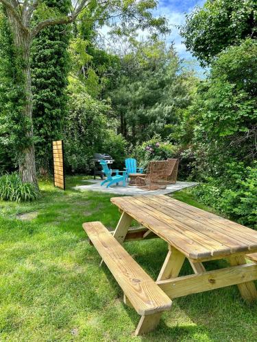 a wooden picnic table in the grass in a yard at 79 West Road Orleans Cape Cod - Bed Splash & Beyond in Orleans