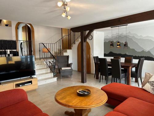 a living room with a television and a dining room at Ferienhaus Andrea mit Whirlpool und Sauna in Rimsting