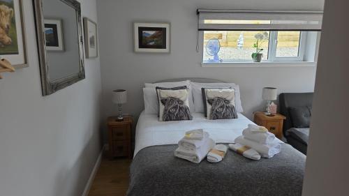 a bedroom with a bed with towels on it at 13 Matheson Place in Portree