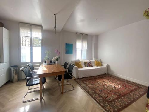 un salon avec une table et un canapé dans l'établissement Renovated Paris 16th flat, à Paris