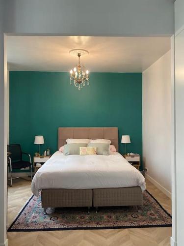 une chambre avec un grand lit avec un mur bleu dans l'établissement Renovated Paris 16th flat, à Paris