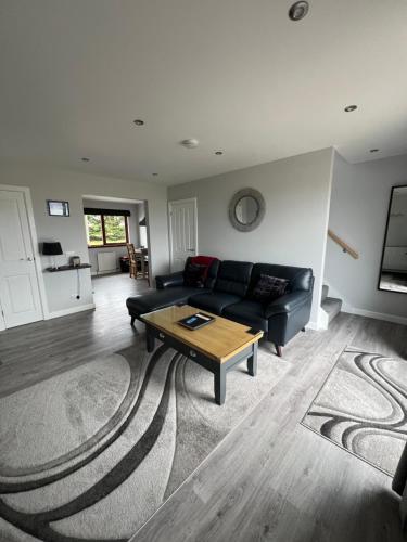a living room with a couch and a coffee table at Ruisgarry Accommodation in Breakish