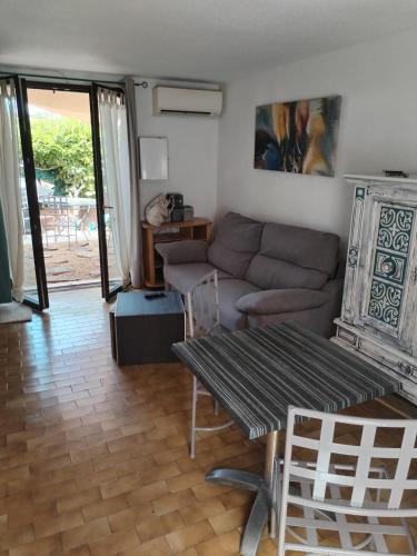 un salon avec un canapé et une table dans l'établissement La Bulle temporelle d'Hélène, à Saint-Cyprien