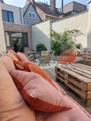 a bunch of pillows sitting on a couch on a patio at Vakantiehuis Vélolit in Oudenaarde