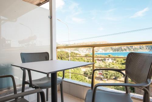 d'une table et de chaises sur un balcon avec vue sur l'océan. dans l'établissement Ionio Rooms, à Himarë