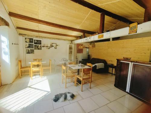 a room with a table and chairs and a dog laying on the floor at La casa sul tetto, Room's & Glamping in Recanati