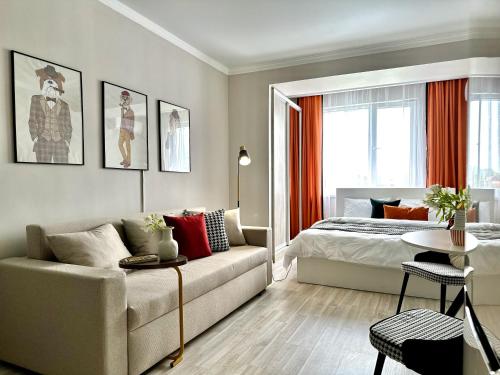 a bedroom with a bed and a couch and a table at Студия ДЭНДИ с видом на горы in Almaty