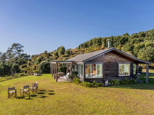 a small cabin in the middle of a field at The Grandstand - Hahei Holiday Home in Hahei