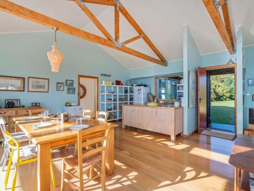 a kitchen and dining room with a table and chairs at The Grandstand - Hahei Holiday Home in Hahei