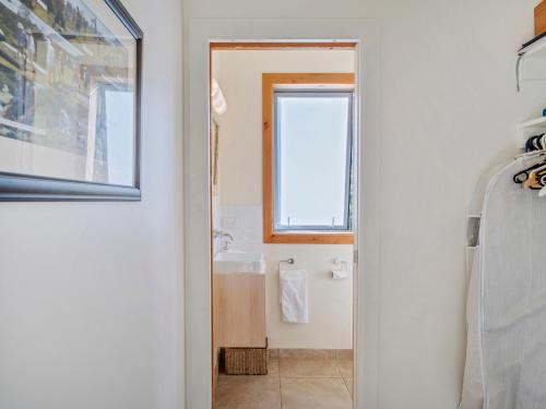 a bathroom with a sink and a window at The Grandstand - Hahei Holiday Home in Hahei