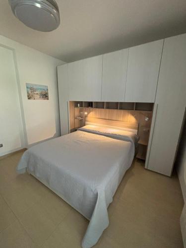 a bedroom with a large white bed in a room at Casa Antia, nuovo bilocale con giardino in Residence con piscina in Numana