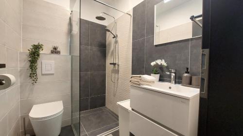 a bathroom with a shower and a toilet and a sink at Orchidea apartman in Balatonalmádi