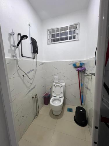 a small bathroom with a toilet and a shower at Kak Pah Homestay Paka in Kampong Baru