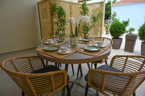 a wooden table with chairs and plates and glasses at Vivis Hub in Argostoli