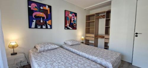 une chambre avec un lit et deux tableaux au mur dans l'établissement Juan 4 prs, clim, 300m plage, piscine, parking, à Antibes