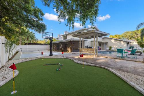 a backyard with a putting green with miniature golf equipment at Pickleball~ Pool~ Game Room~ 5 min to Beach in Seminole