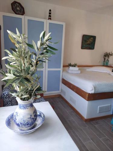 a bedroom with a bed and a vase with a plant on a table at Elies apartments 2 in Alinda