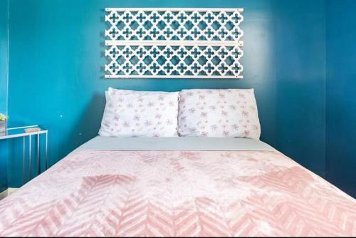 a bed with a pink blanket and a blue wall at 2 bedroom home in Dayton in Dayton