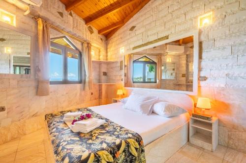 a bedroom with a bed in a room with windows at Paco's Resort Luxury Villa 19 in Oziás