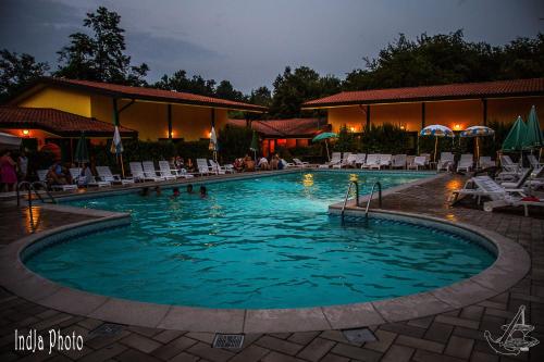 a swimming pool at a resort at night at Hotel Ristorante La Perla in Varallo Pombia