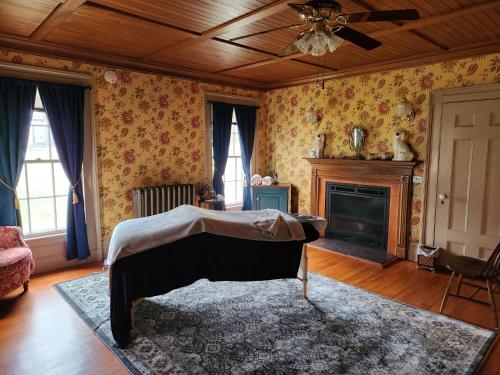 a living room with a bed and a fireplace at Arlington Inn & Spa in Arlington