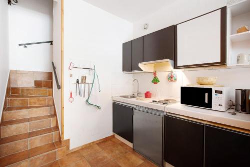 a kitchen with black cabinets and a microwave at Appartamenti Larice Pila in Pila