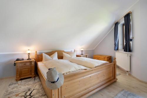 a bedroom with a large wooden bed with white sheets at Pension Bergblick in Marienberg