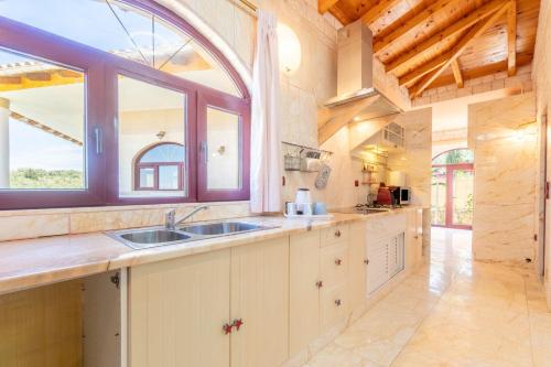 a kitchen with a sink and a large window at Paco's Resort Luxury Villa 31 in Oziás