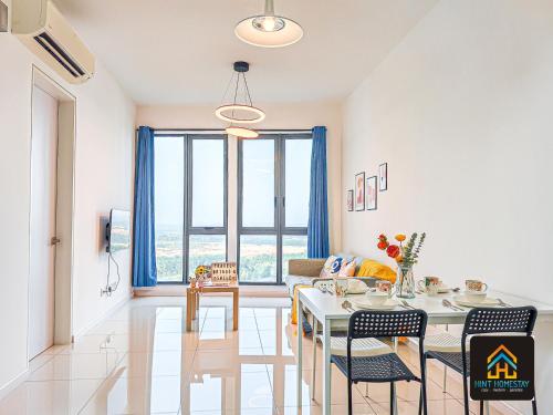 a living room with a table and chairs and a couch at Medini Elysia Park , 3 min to Legoland, Netflix By Hint Homestay in Nusajaya
