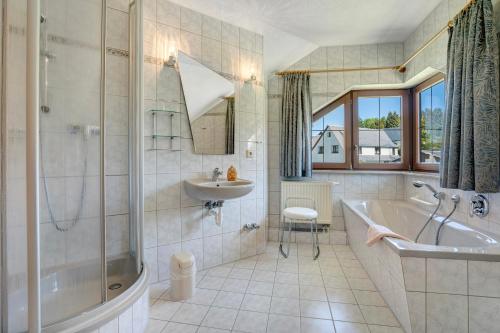 a bathroom with a tub and a sink and a bath tub at Pension Bergblick in Marienberg