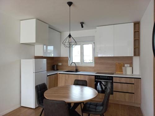une cuisine avec une table en bois et une table et des chaises dans l'établissement Apartman Filip, à Poljica