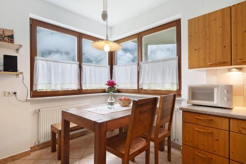 a kitchen with a table with chairs and a microwave at Kati´s Haus in San Pancrazio dʼUltimo