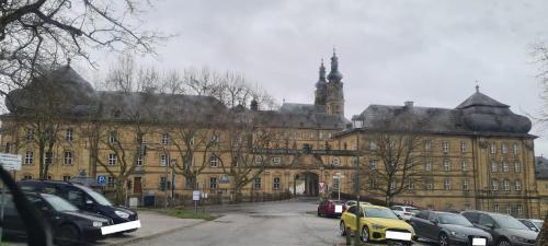 Un gran edificio con coches aparcados delante. en Ferienwohnung Markert, en Bad Staffelstein