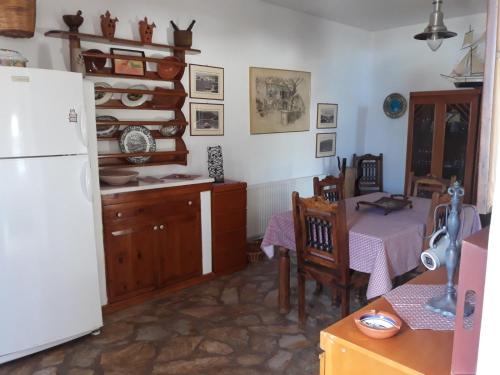 a kitchen with a table and a white refrigerator at Elies Apartments in Alinda