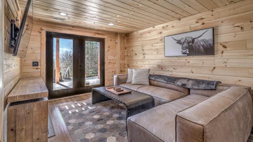 a living room with a couch in a log cabin at Tranquility Ranch in Mineral Bluff