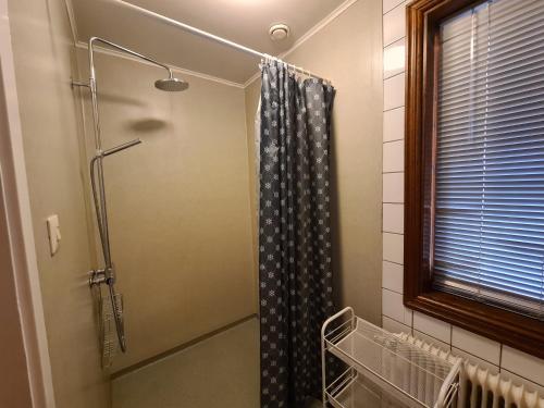 een douche met een douchegordijn in de badkamer bij Tostarps Pensionat in Hässleholm