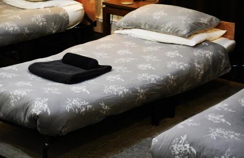 a bed with a black towel on top of it at Hillfields Farm Barn - A Rural Equestrian Escape in Coventry