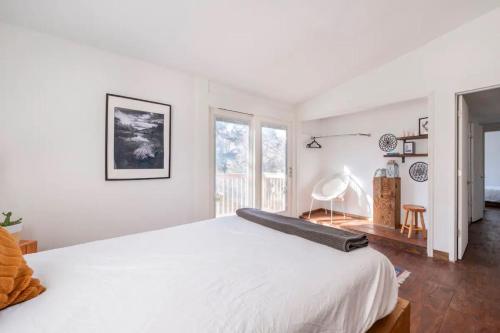 a white bedroom with a large bed and a window at Serene Catskills Retreat with Deck in Woodbourne