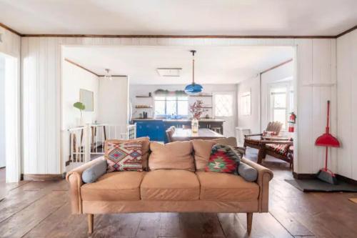 a living room with a couch and a kitchen at Serene Catskills Retreat with Deck in Woodbourne