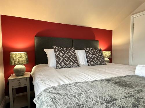 a bedroom with a bed with a red wall at The Prince Albert Pub & Hotel with onsite FREE PARKING 2 minutes from Legoland in Windsor