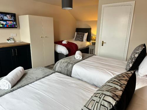 a bedroom with two beds and a tv in it at The Prince Albert Pub & Hotel with onsite FREE PARKING 2 minutes from Legoland in Windsor