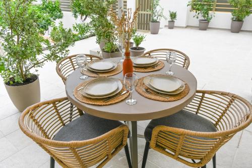 a table with chairs and plates and glasses on it at Vivis Hub in Argostoli