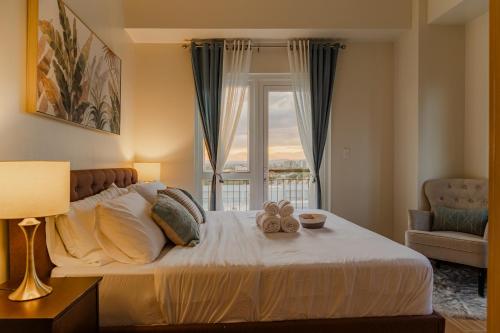 a bedroom with a large bed with a window at 2 BR 5 pax Spacious Elegant Condo in Saint Dominique, Megaworld, Iloilo City in Iloilo City