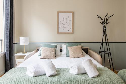 une chambre avec un lit avec des oreillers dessus dans l'établissement Modern spacious studio only 1 minute away from the Place de la République, à Paris