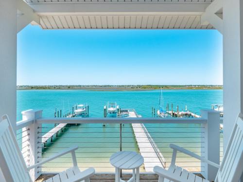a porch with chairs and a dock on the water at Channel 6 in Surf City