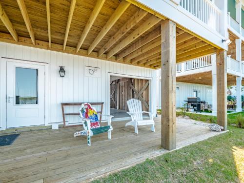 a porch with two chairs and a wooden roof at Channel 6 in Surf City