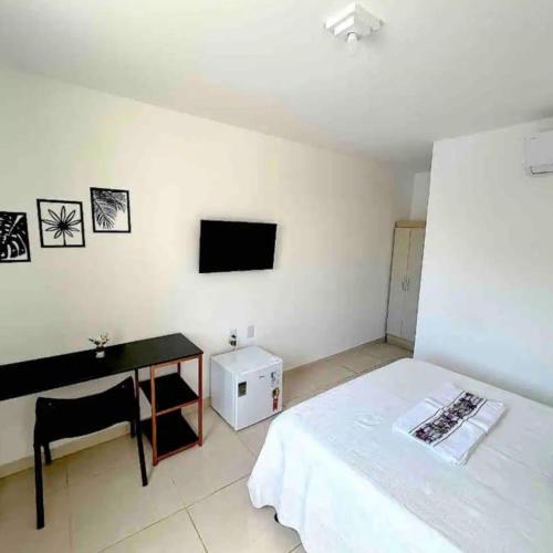 a bedroom with a bed and a desk and a television at Casa De Praia Com Seis Súites Climatizadas in Lauro de Freitas