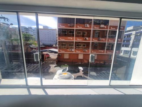 a view of a building through a window at Hotel Kolman in Capão da Canoa